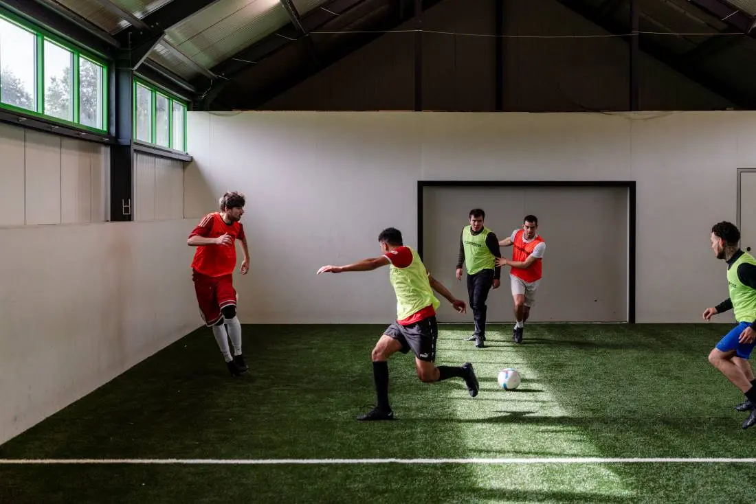 Kandidaten voetballen samen tijdens voetbalproject